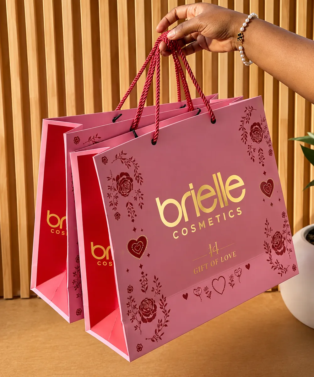 Kraft and ivory paper bags with satin webbing handles.